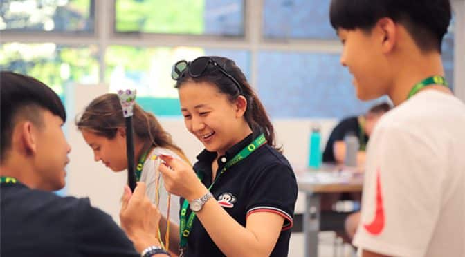 Camp staff member helping a camper, part of the rewarding experience of working at camp