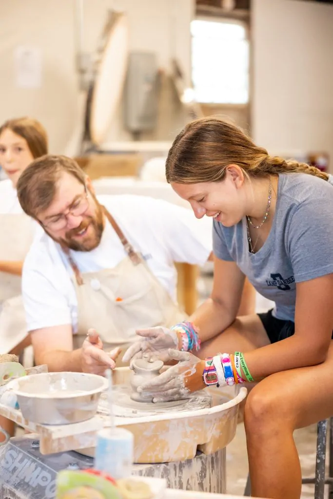 summer camp girl and instructor learning pottery
