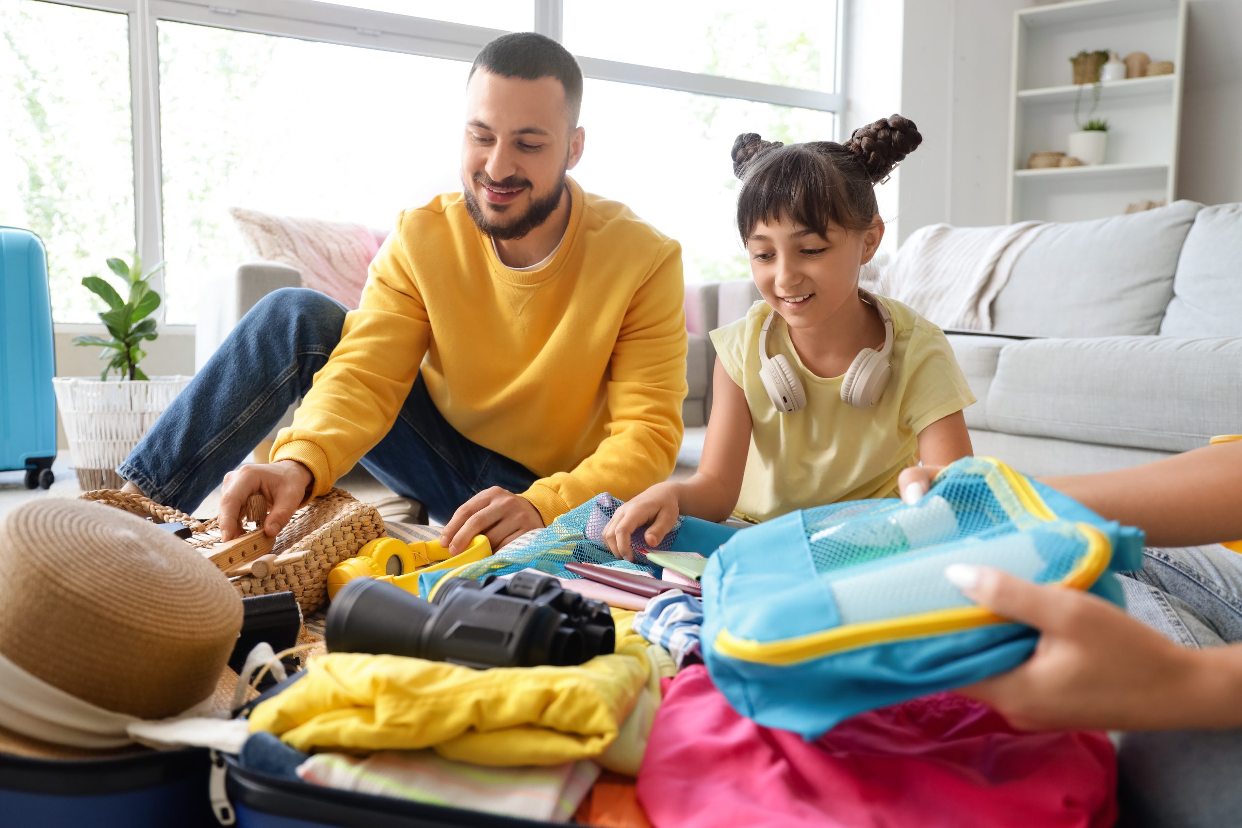 Family packing a suitcase to prepare for summer camp