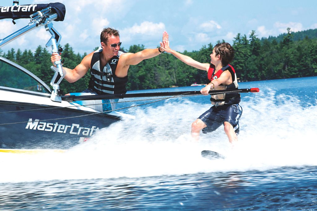 Waterskier high fiving the instructor at summer camp