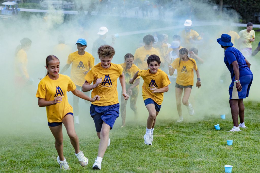 A group of campers celebrate together during a soccer session at a sports-focused camp