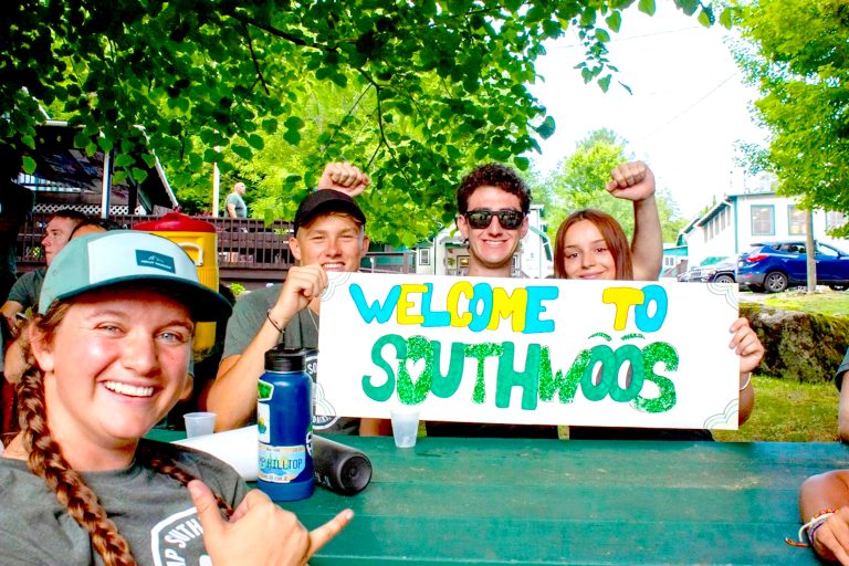 Campers holding a handmade Welcome to Camp Southwoods sign