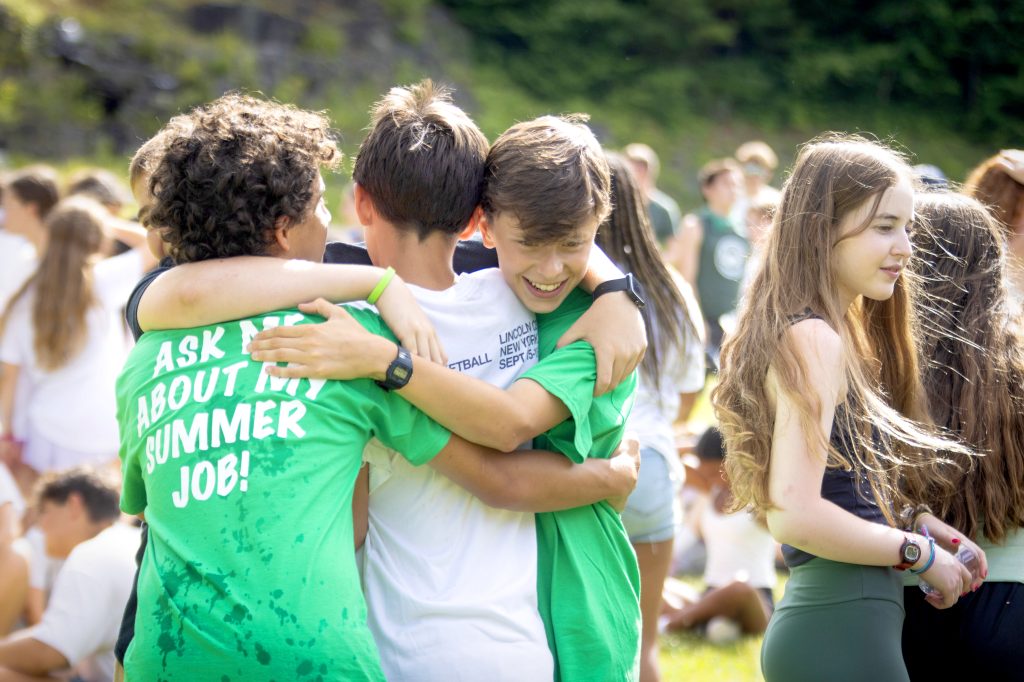 A group of campers sharing a warm group hug at camp